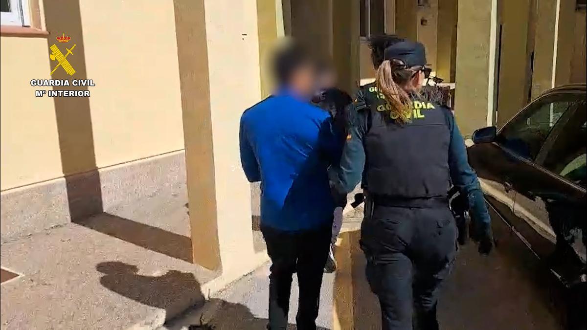 Los agentes custodian a uno de los detenidos
