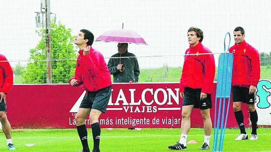 Sergio golpea un balón de cabeza en un partido de futvoley observado por Juan Muñiz y Pedro Orfila.