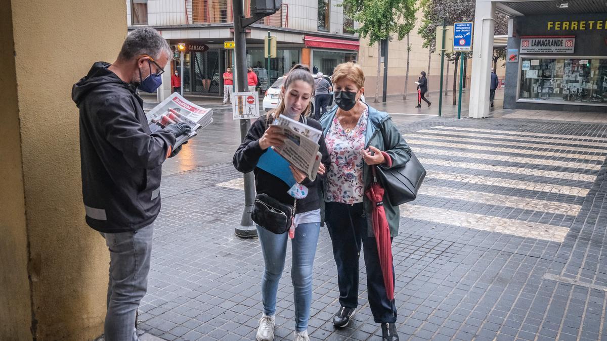 Varios lectores reciben sus revistas.