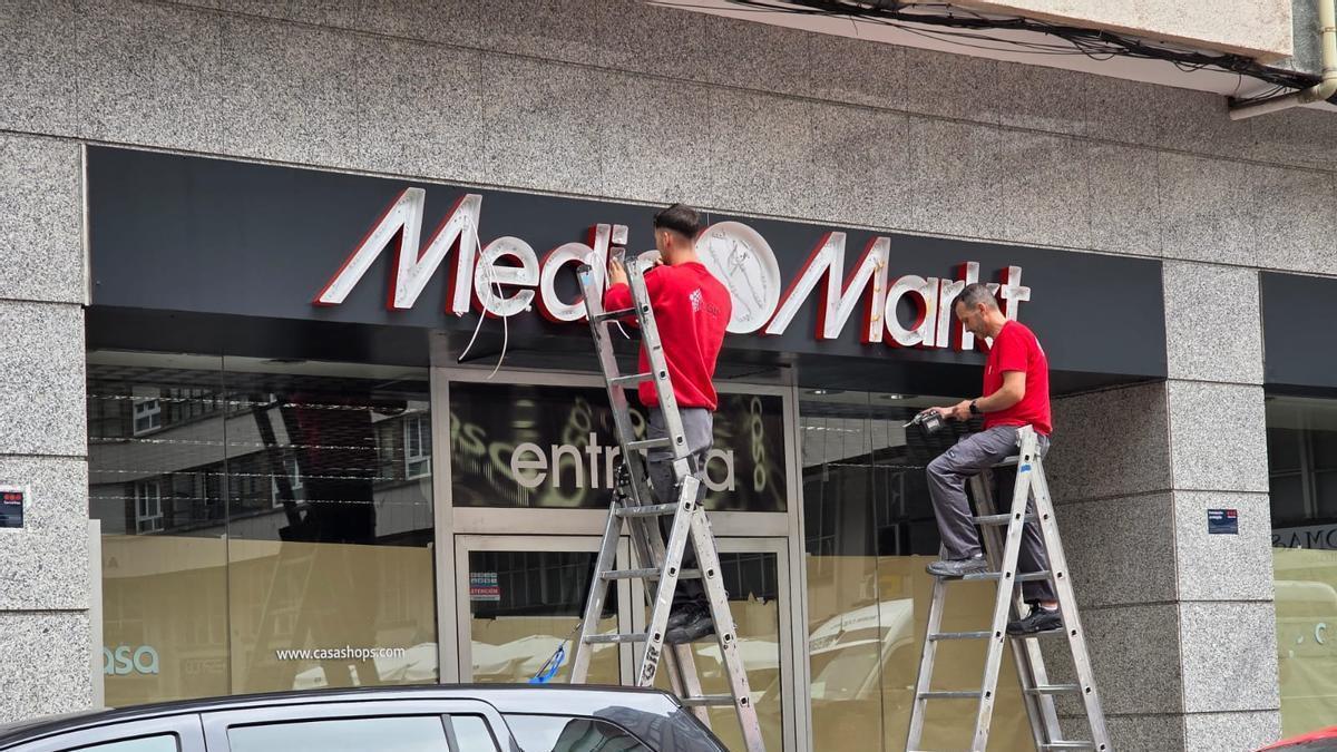 Los operarios colocan el rótulo edl próximo Media Markt en la calle José Cueto.
