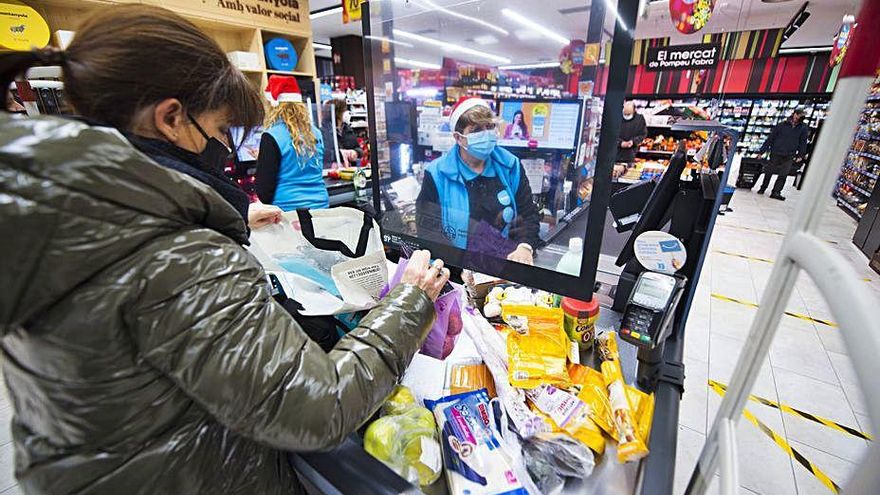 Una clienta guardant la compra en un supermercat a Manresa