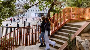 Alumnas del centro concertado Garbí bajan las escaleras del patio, con vistas a las instalaciones del instituto de alta complejidad Joanot Martorell, en Esplugues.