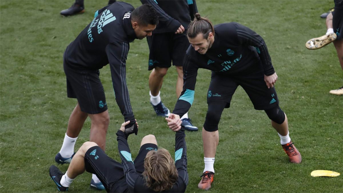 Marcelo y Gareth Bale ayudana a Luk Modric durante un entrenamiento del Real Madrid