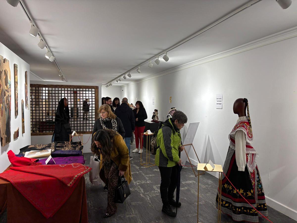 Familiares e invitados a la exposición admiran las obras de la costurera toresana.