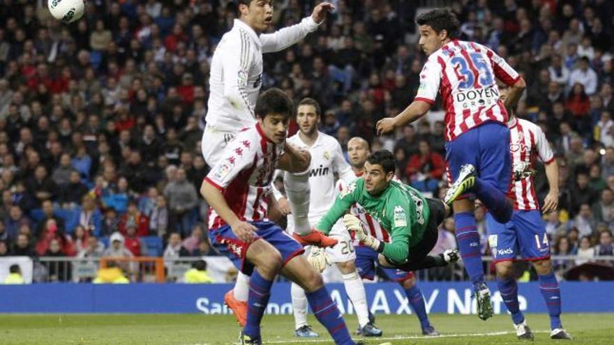 Moisés, con el número 35, despeja un balón de cabeza ante la presión de Cristiano Ronaldo.