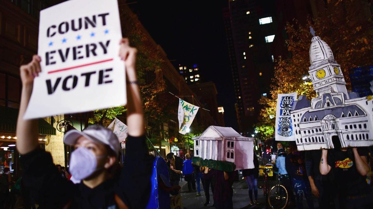 Manifestantes reclaman que se cuente cada voto, anoche frente a un centro de recuento en Filadelfia.