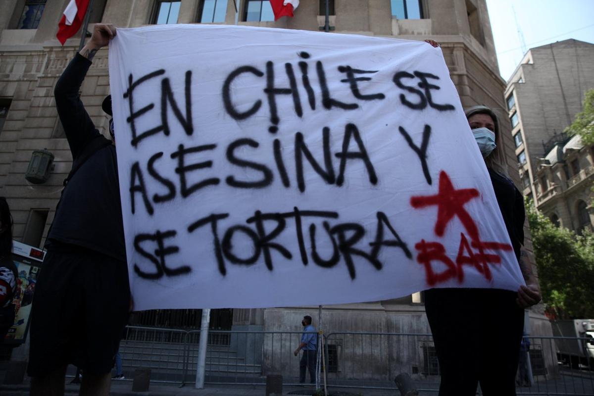 Relatives and supporters of people who died during recent protests hold a sign reading ’In Chile, people are murdered and tortured’ as they gather to request justice outside government house in Santiago, Chile November 18, 2020. REUTERS/Ivan Alvarado