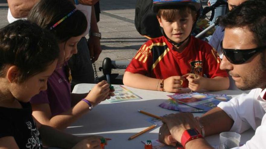 Tres niños, en uno de los talleres infantiles de ayer, a cargo de Cruz Roja Juventud.