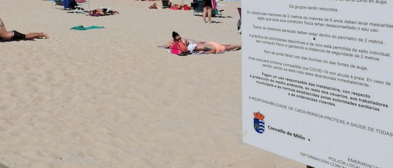 Playa Grande de Miño, con un cartel informativo en primer término.