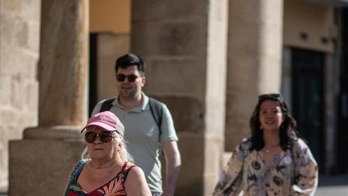 Una mujer pasea por la Plaza Mayor de Zamora con una gorra para protegerse del intenso sol. | E. Fraile