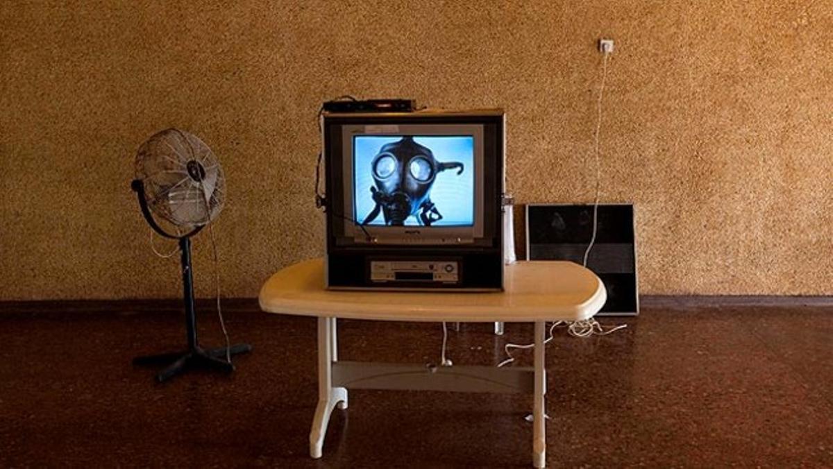 En un televisor es projecta un vídeo de l’Exèrcit israelià que explica com usar una màscara de gas.