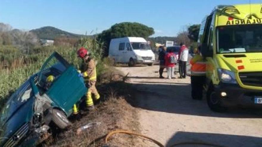 Una de les furgonetes va quedar bolcada al costat de la via.