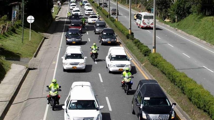 Caravana de coches que llevan los cuerpos de los jugadores. // Efe