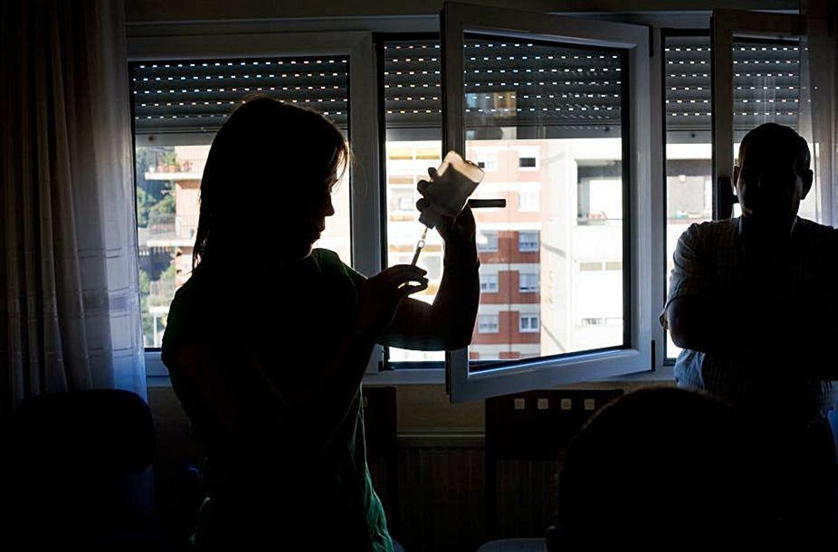 Dos profesionales sanitarios, en un domicilio de un anciano en Avilés.