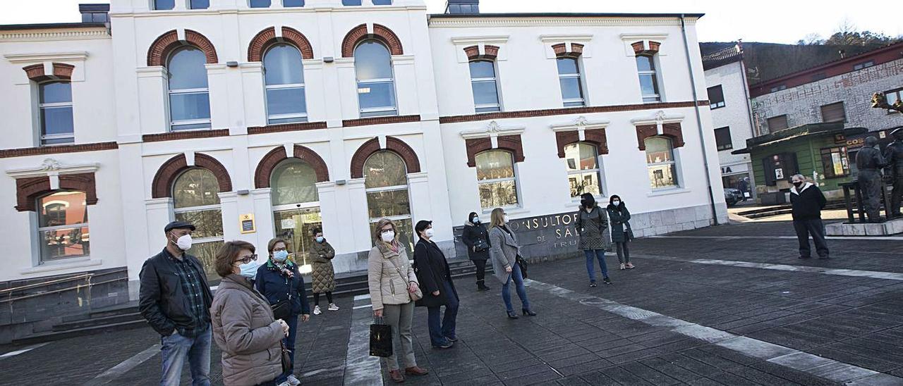 Vecinos de concentrados frente al consultorio periférico de Trubia para exigir mejores servicios sanitarios en la localidad. En detalle, la plaza de ambulancia del centro desocupada | Miki López