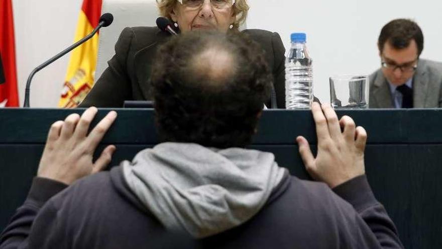 Manuela Carmena dialoga con Zapata en el transcurso del pleno. // Efe