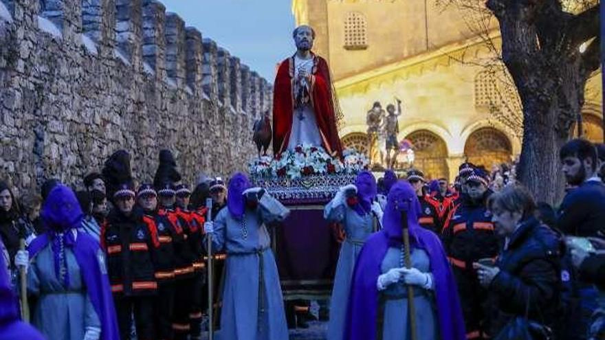 El paso de San Pedro, llevado a hombros por cofrades, con el templo parroquial al fondo.