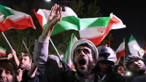 Varios manifestantes ondean banderas de Palestina e Irán frente a la embajada del Reino Unido en Teherán, momentos después de los ataques a Israel.