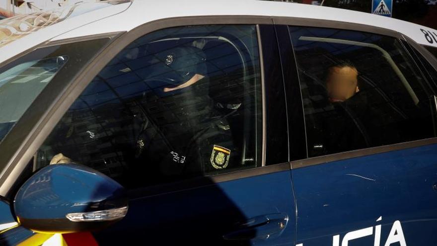 Uno de los acusados, en un coche policial.