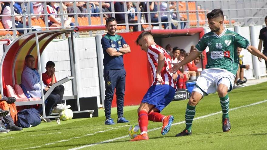 Un jugador del Coruxo defiende a un rival colchonero. // @AtletiAcademia