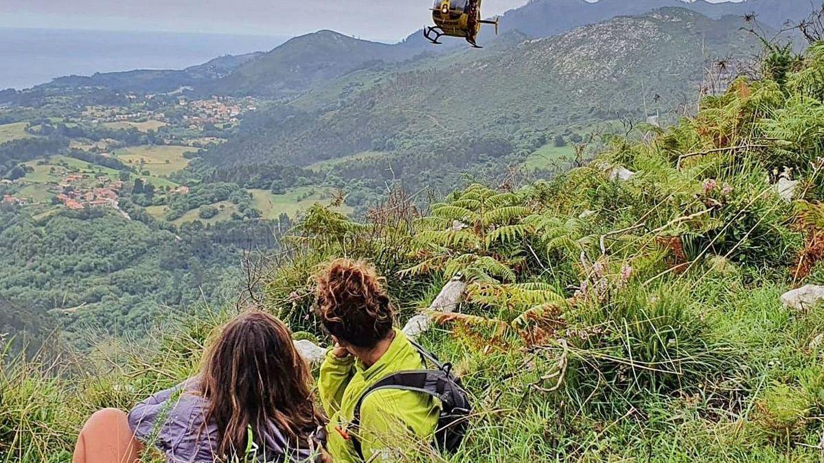 Dos de las tres mujeres rescatadas esperan el helicóptero tras la evacuación de su compañera.