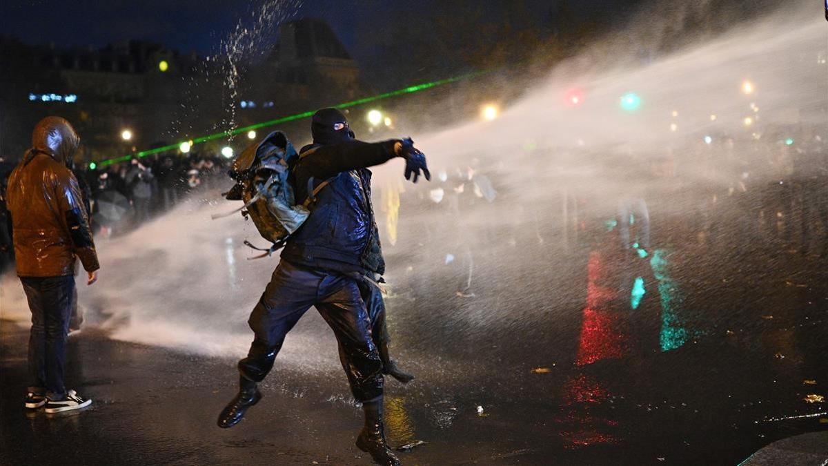 Los manifestantes lanzan objetos a la policía francesa en la protesta contra la ley de seguridad.