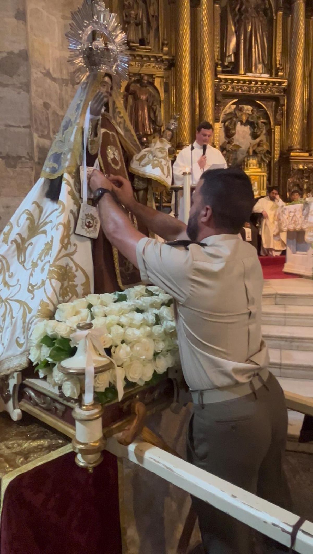Uno de los militares coloca la medalla a la Virgen.