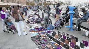 Els agents de la policia espanyola inspeccionen els articles falsificats intervinguts a Badalona i que posteriorment es venien als voltants del Port de Barcelona. 