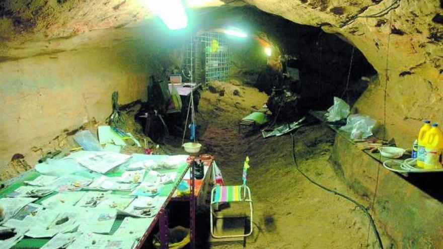 Arriba, interior de la cueva de Sidrón en plena excavación; en la mesa de la izquierda se observan los fósiles extraídos. Bajo estas líneas, la figura de una neandertal en el Sueve, con los Picos de Europa al fondo, en un reportaje de «National Geographic».