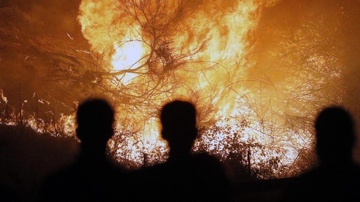 Personas observan impresionados el incendio en Chandebrito.