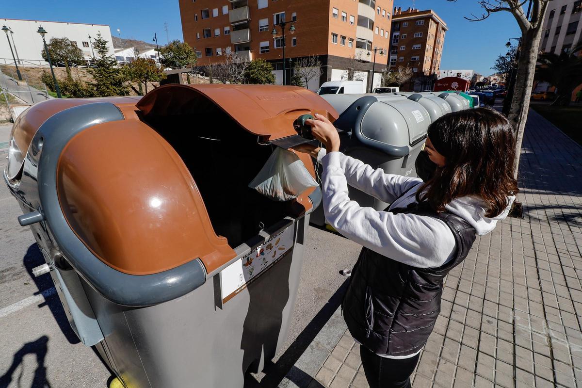 Un usuario deposita la fracción orgánica en un contenedor marrón en Alcoy, en imagen de archivo