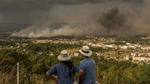 Dos personas observan el incendio de Verín