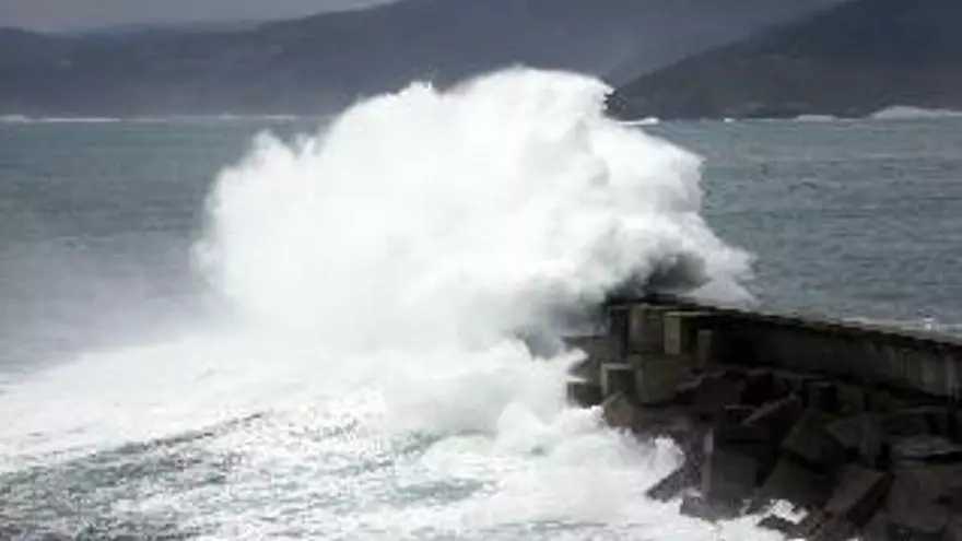 Las olas superan el dique del Puerto de Malpica