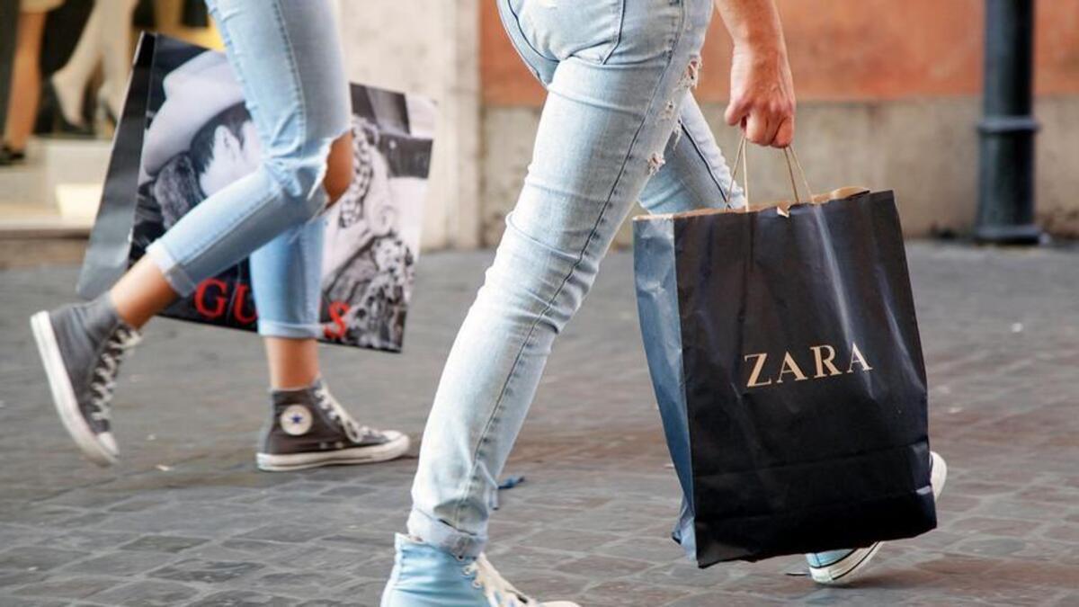 Dos personas pasean con bolsas de Zara.