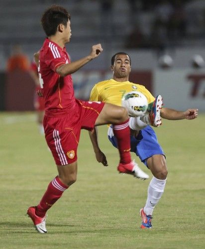 Brazil's Lucas fights for the ball with China's Yu Yang during their international friendly soccer match in Recife
