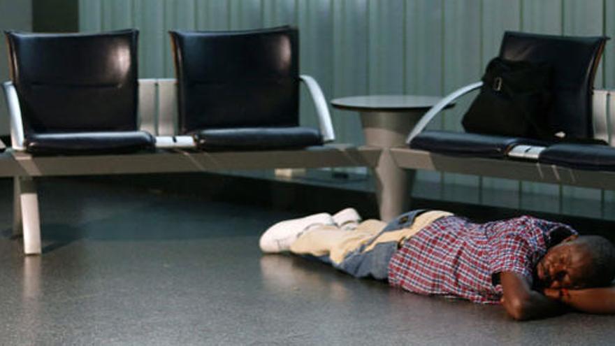 Una persona duerme en el aeropuerto de Frankfurt.
