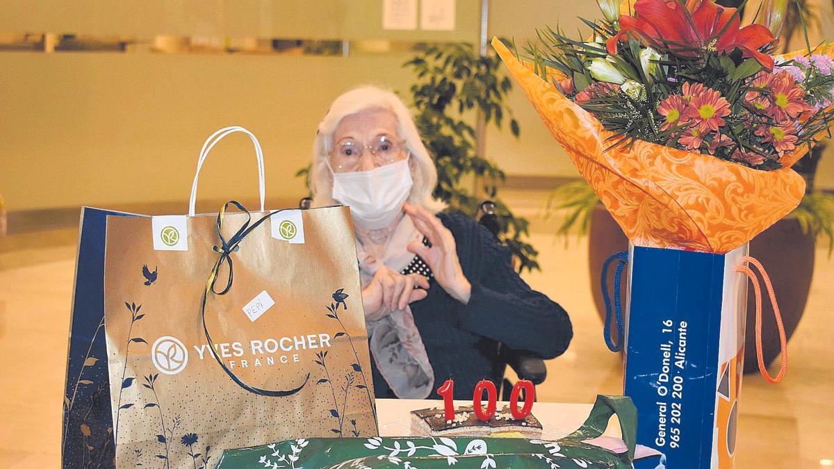 Aurora Sirvent, en la residencia de ancianos de Alicante donde vive, con los regalos de su centenario, que fueron desinfectados.