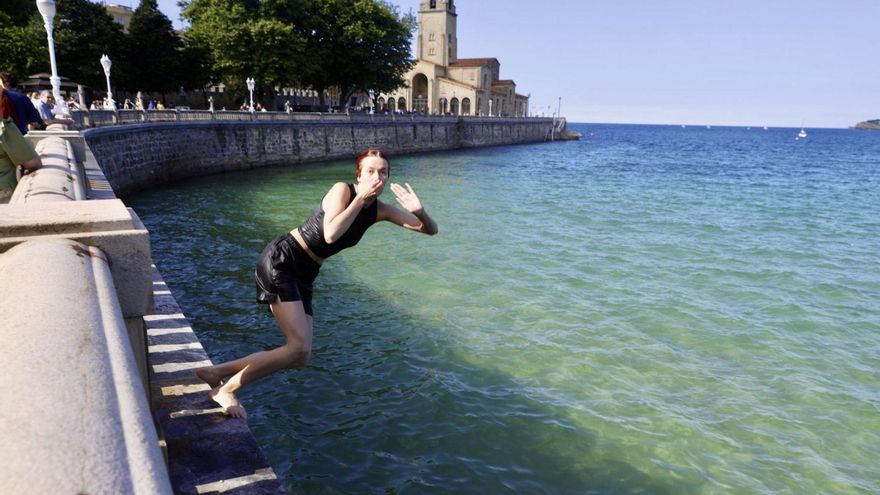 Una joven saltando al agua desde el paseo del Muro.