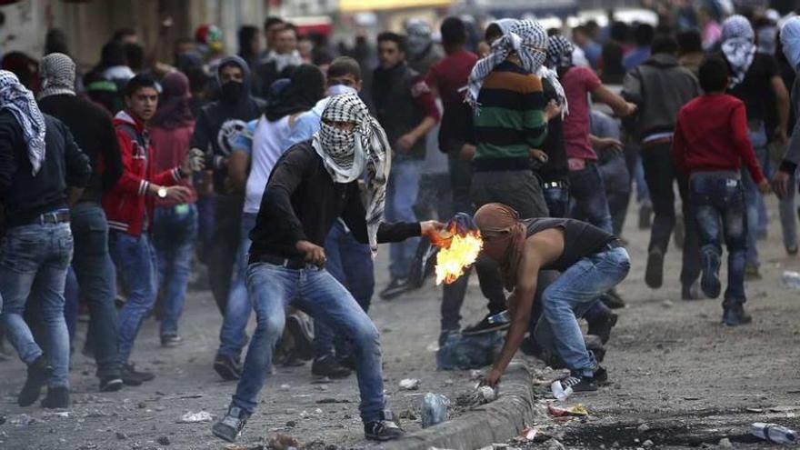 Un manifestante palestino lanza un cóctel molotov contra soldados israelíes durante un choque en la localidad cisjordana de Hebrón.  // Efe