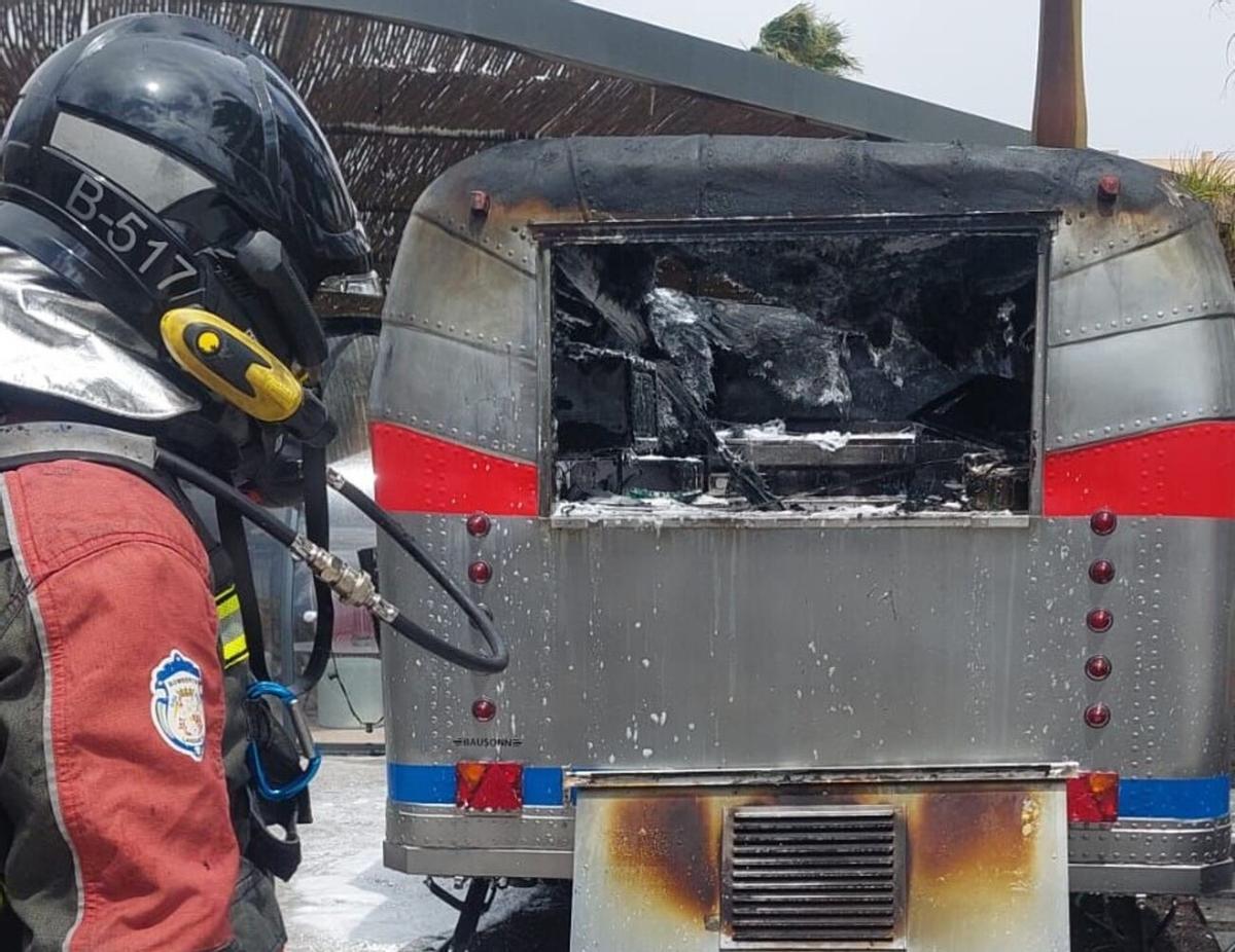 Un bombero del Consorcio de Seguridad y Emergencias de Lanzarote, ayer, jueves 9 de abril, junto a la caravana de comidas que ardió junto a un hotel en Costa Teguise, en Lanzarote.