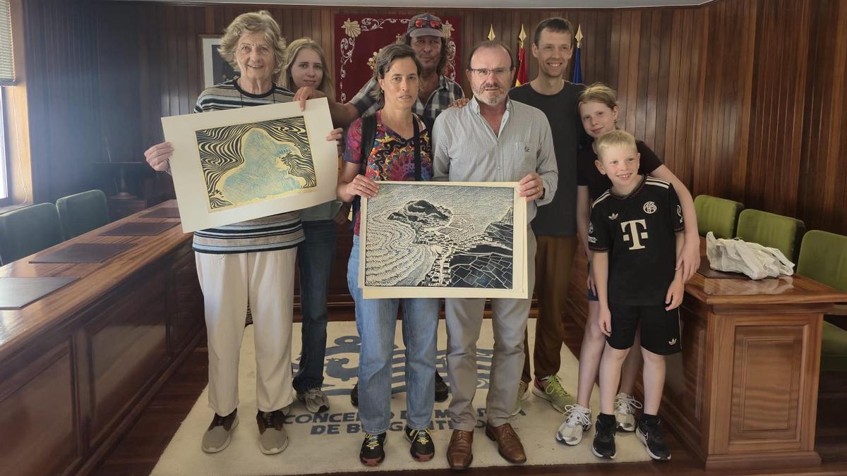 Eduardo Parga, diante, á dereita, con familiares de Theodor Schücker, sostendo dúas das obras doadas.