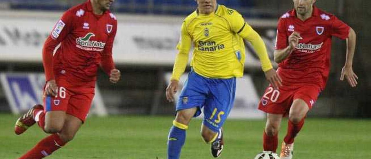 Roque Mesa conduce la pelota ante la presión de Antonio Tomás durante el Numancia-UD Las Palmas de ayer.