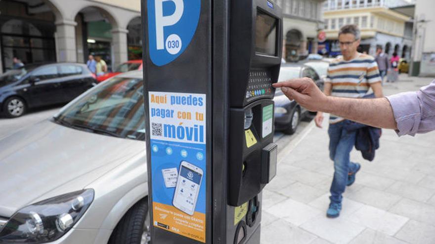 Un usuario de la ORA maneja un parquímetro en A Coruña.