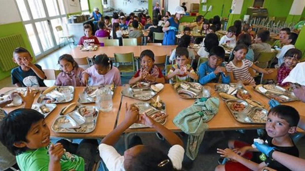 Unas monitoras atienden a los alumnos mayores en el comedor escolar del colegio Antaviana, en el barrio de Roquetes de Barcelona, ayer.