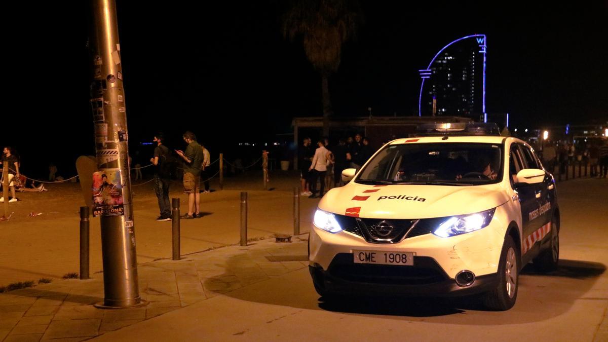 Un cotxe dels Mossos patrulla per la Barceloneta poc abans del toc de queda.