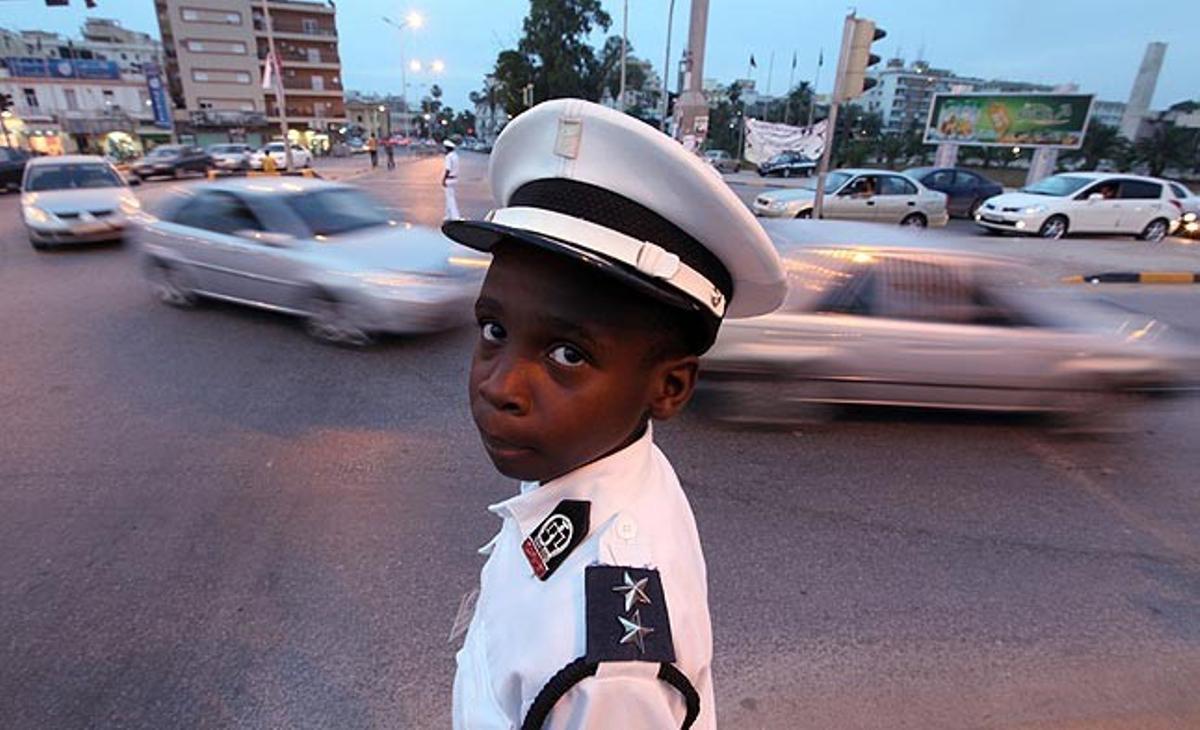 Ante la falta de policías en Libia debido al conflicto, un joven voluntario de 10 años controla el tráfico este jueves en una calle de Bengasi.
