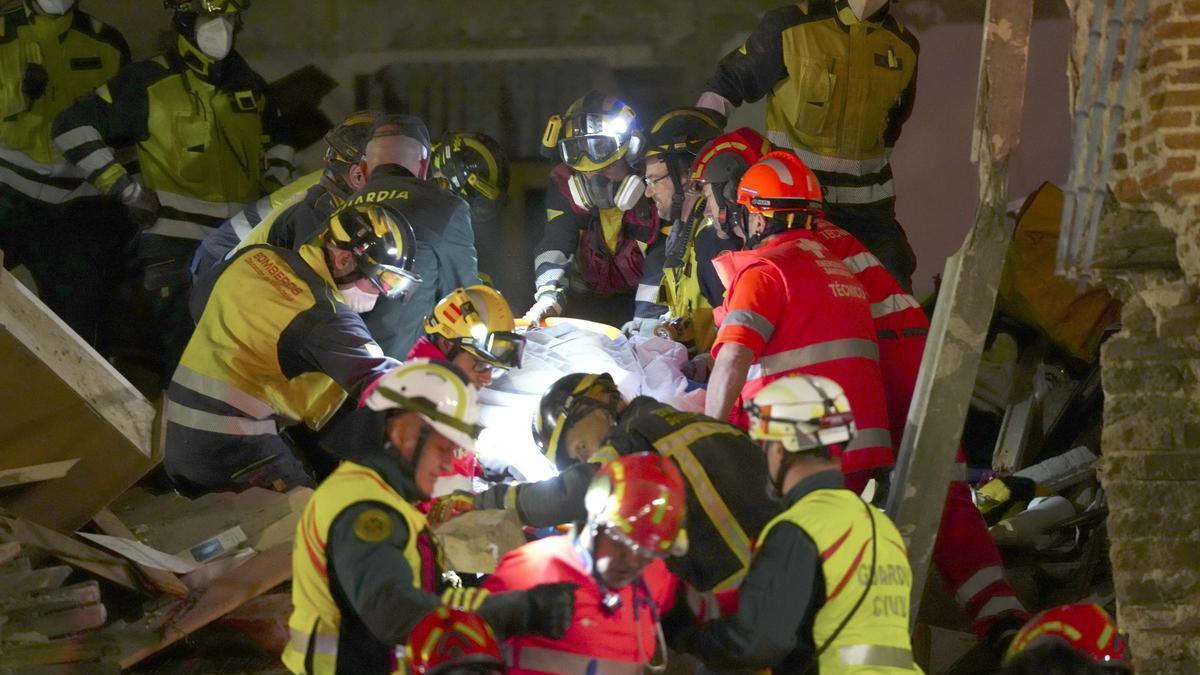 Servicios de emergencias rescatan a uno de los supervivientes en el derrumbe de una vivienda en Valladolid