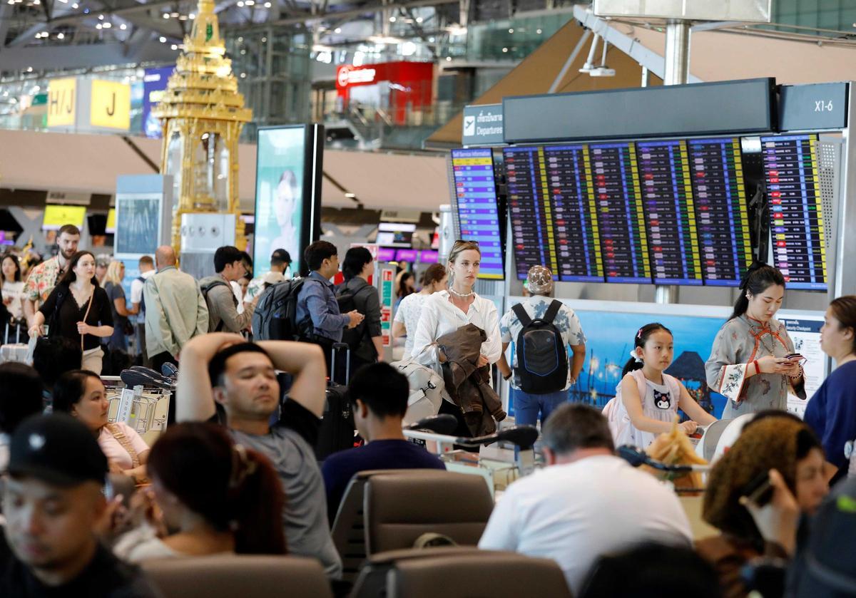 Pasajeros atravedos en un aeropuerto de Tailandia por la crisis en Oriente Medio.