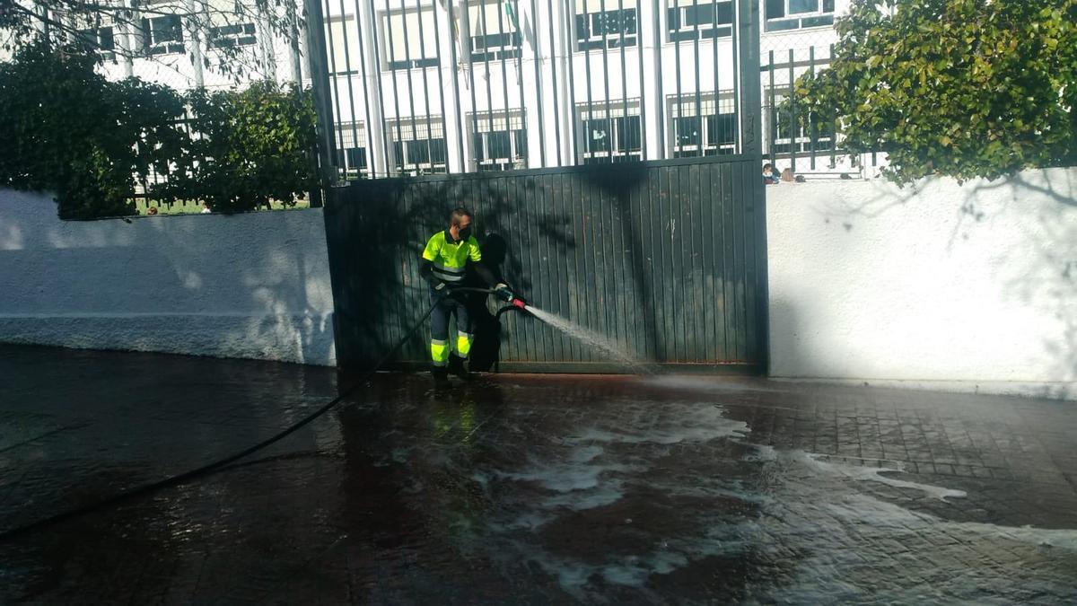 Un operario municipal limpia los alrededores de un colegio de Ronda.