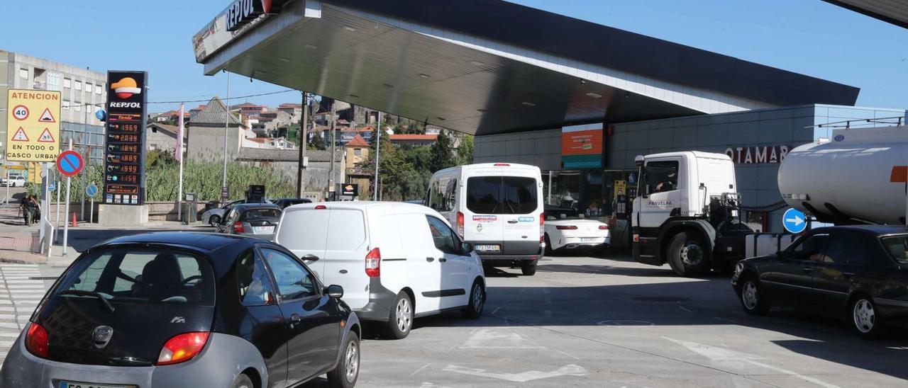 Coches con matrícula portuguesa haciendo cola, ayer, en una estación de servicio de Repsol en el concello de Tui (Pontevedra).